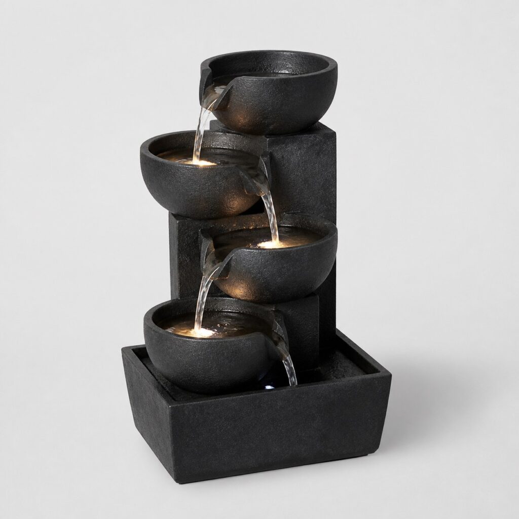 Petite fontaine en résine noire à quatre vasques sur fond gris clair
