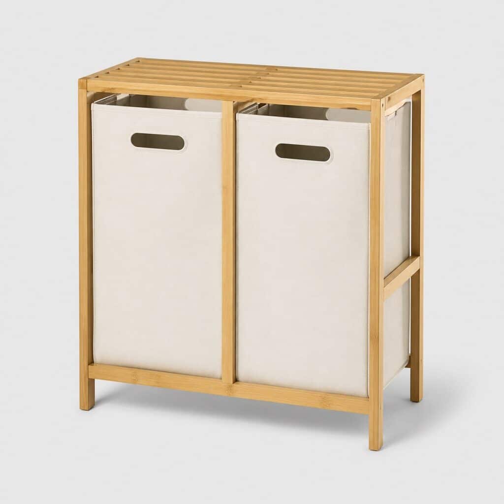 Meuble panier à linge deux compartiments en bambou et tissu écru sur fond gris clair