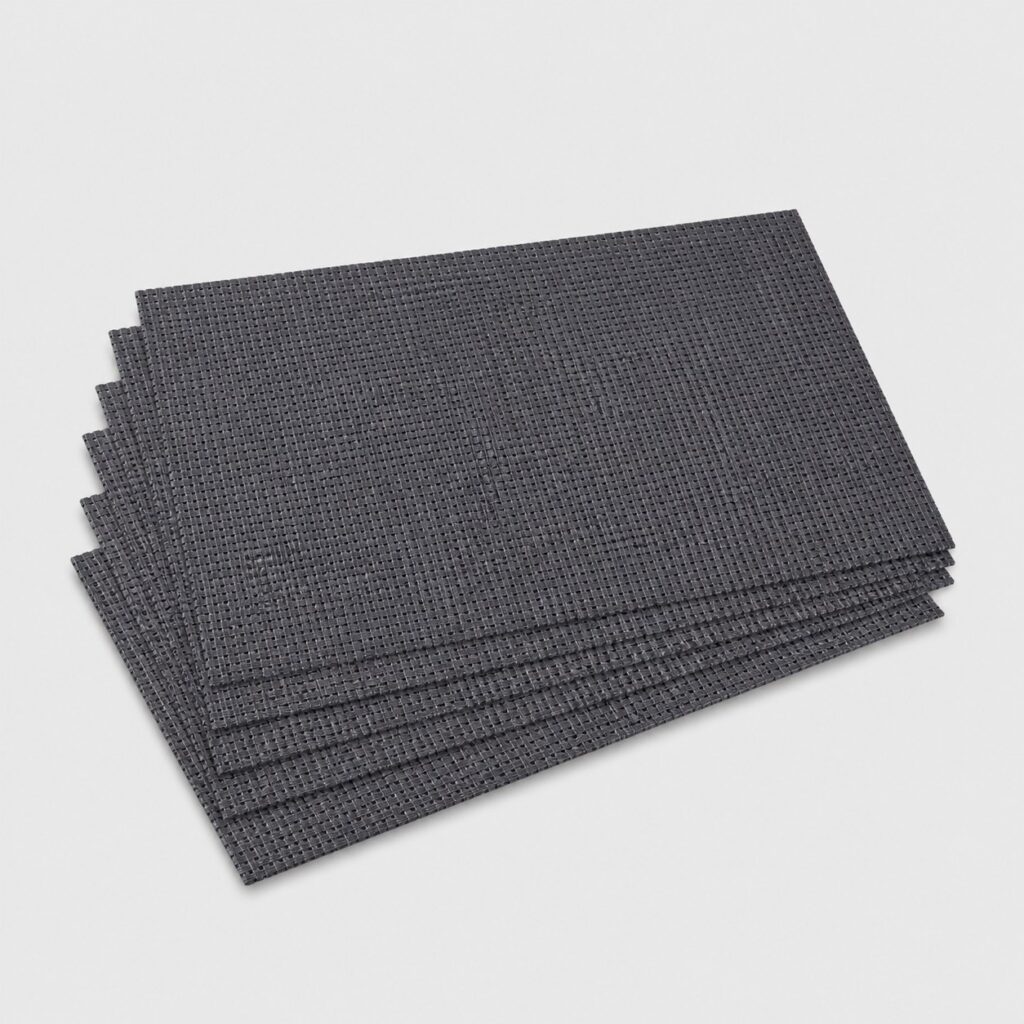 Six sets de table en PVC tissé gris anthracite sur fond gris clair